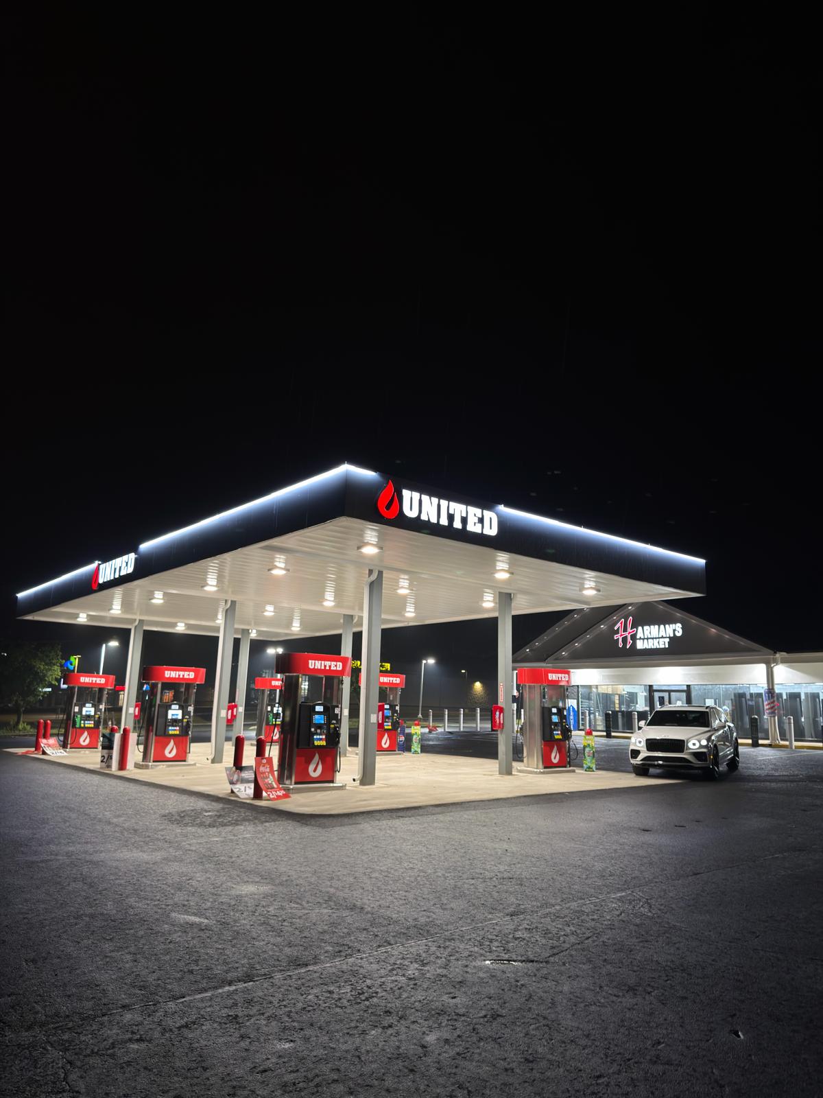United Gas & Harman's Market storefront at night